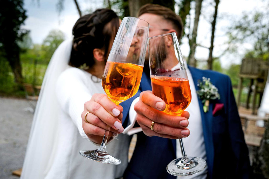 brautpaar_mit_sektgläsern_hochzeitsfotografie_hochzeitsfeier